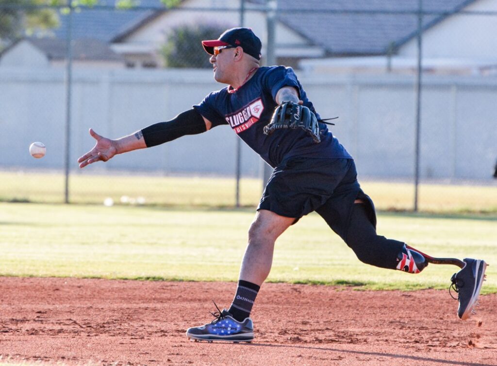 A man in black shirt playing baseball on dirt field.