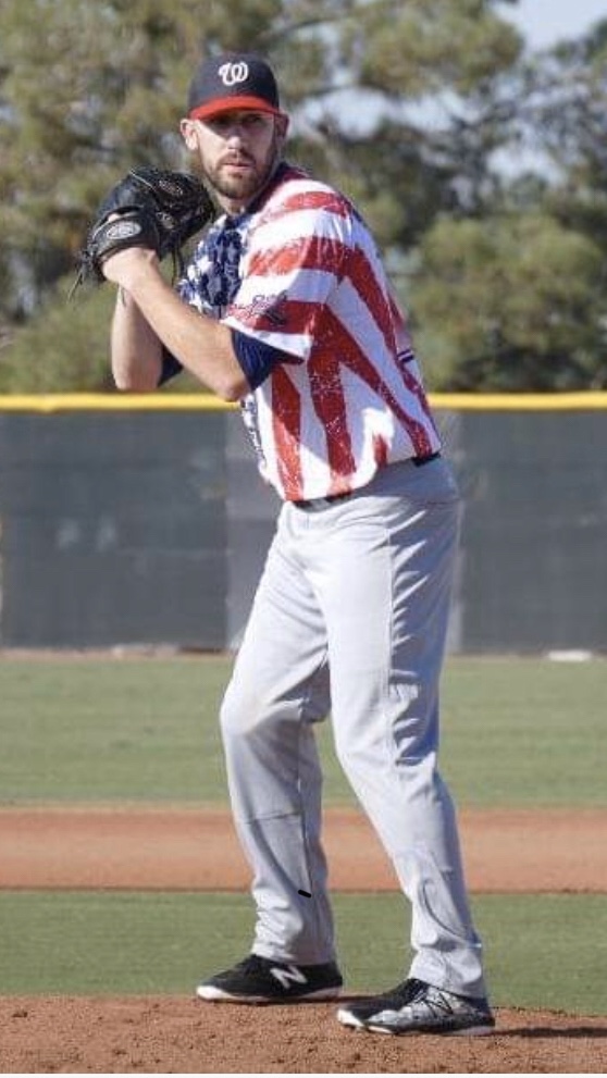 A baseball player is wearing an american flag shirt.