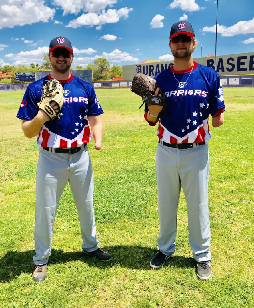 Two baseball players standing on a field with their gloves.