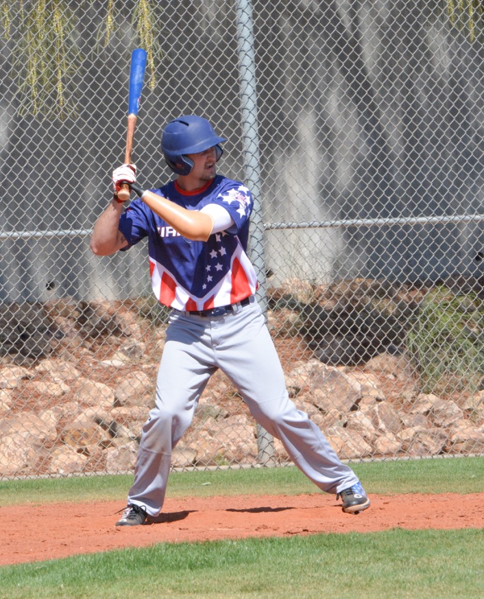 A baseball player is holding his bat ready to swing.