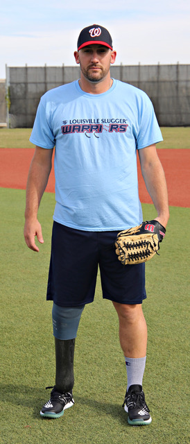A man in blue shirt holding a baseball glove.