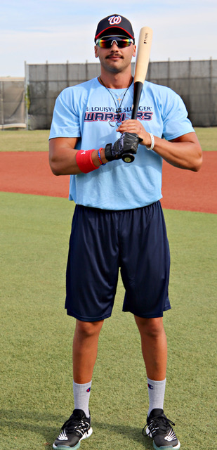 A man in blue shirt holding a baseball glove.