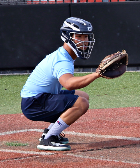 A baseball player squatting down on the field