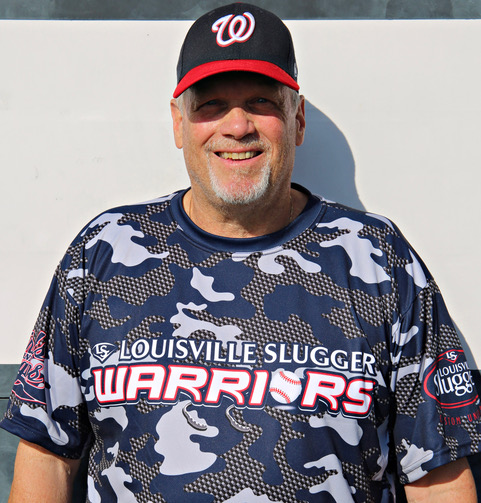 A man in a baseball uniform poses for the camera.