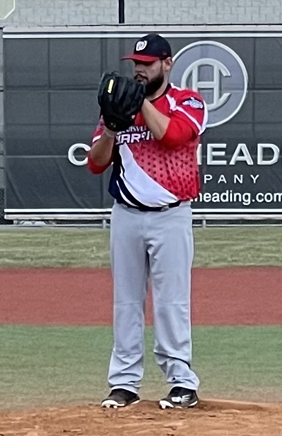 A baseball player is holding his glove up.