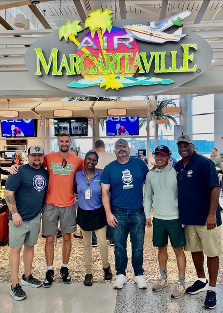 A Group of People Standing Below Margaritaville Sign