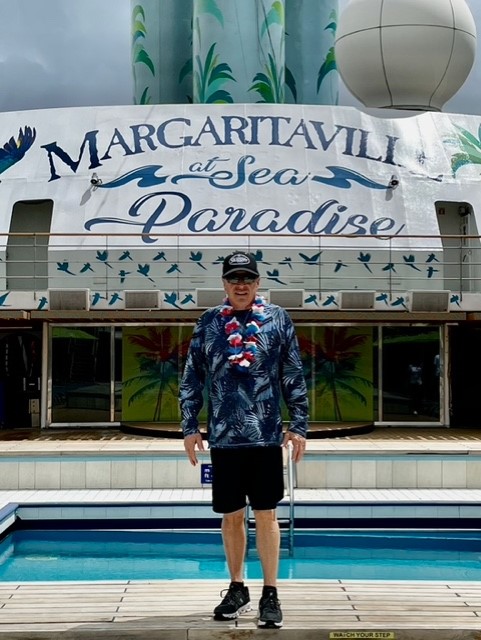 A man standing in front of a pool with a sign on the side.
