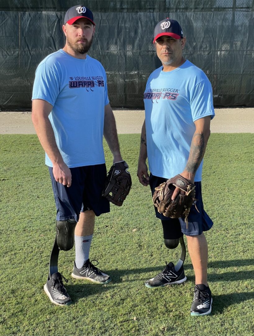 Two men standing on a field holding baseball gloves.