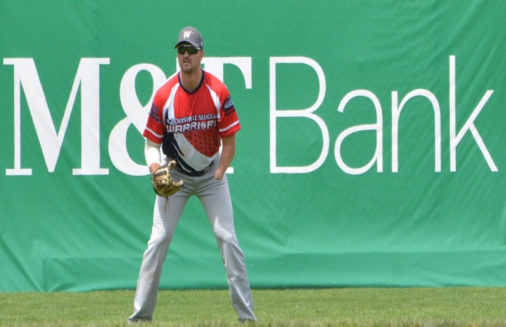 A baseball player is standing in the outfield.